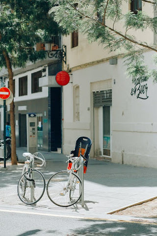 White city bike parked beside a white concrete building